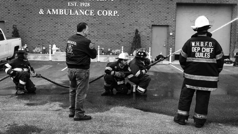 Black and white image of members and fire hose