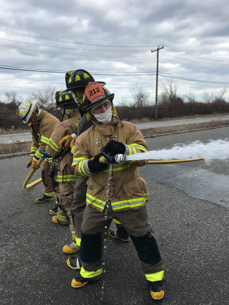 4 members using a fire hose